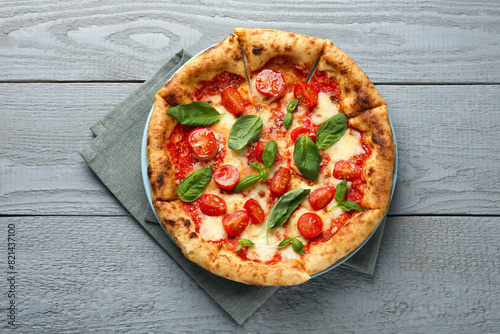 Delicious Margherita pizza on gray wooden table, top view