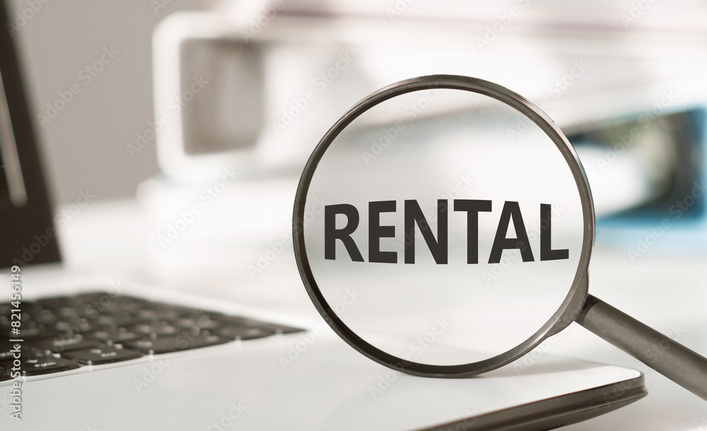Magnifying Glass Focused on the Word Rental Against a Blurred Background Magnifying Glass Focused on the Word Rental Against a Blurred Background