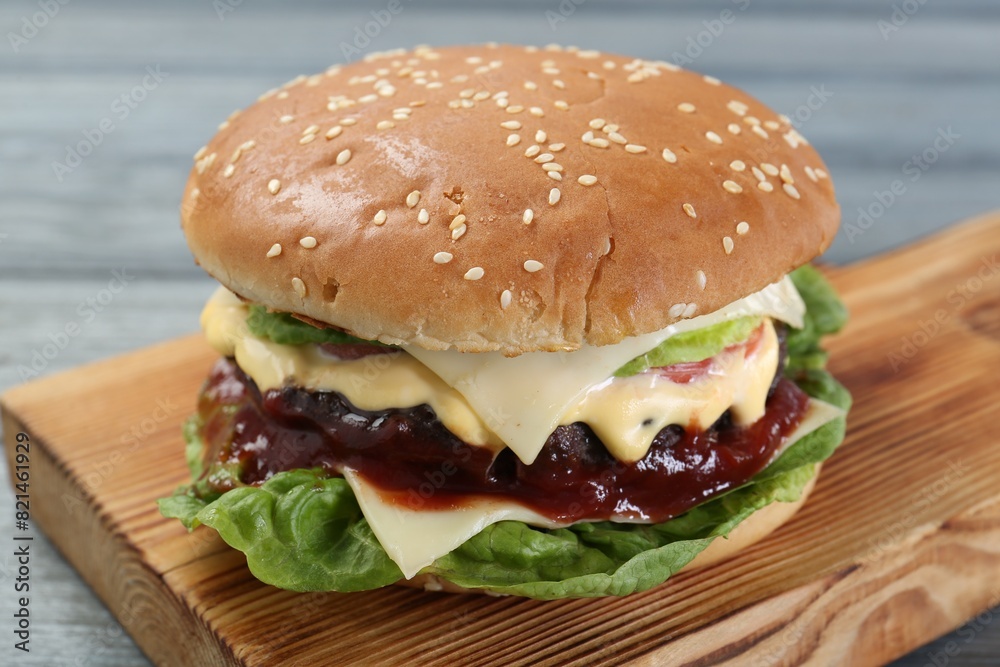 Tasty homemade cheeseburger with lettuce on grey table, closeup Tasty homemade cheeseburger with lettuce on grey table, closeup