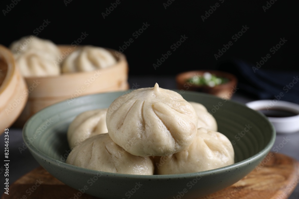 Delicious bao buns (baozi) in bowl on grey table, closeup Delicious bao buns (baozi) in bowl on grey table, closeup