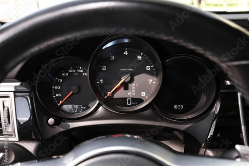 Steering wheel, speedometer and tachometer inside of modern car, closeup