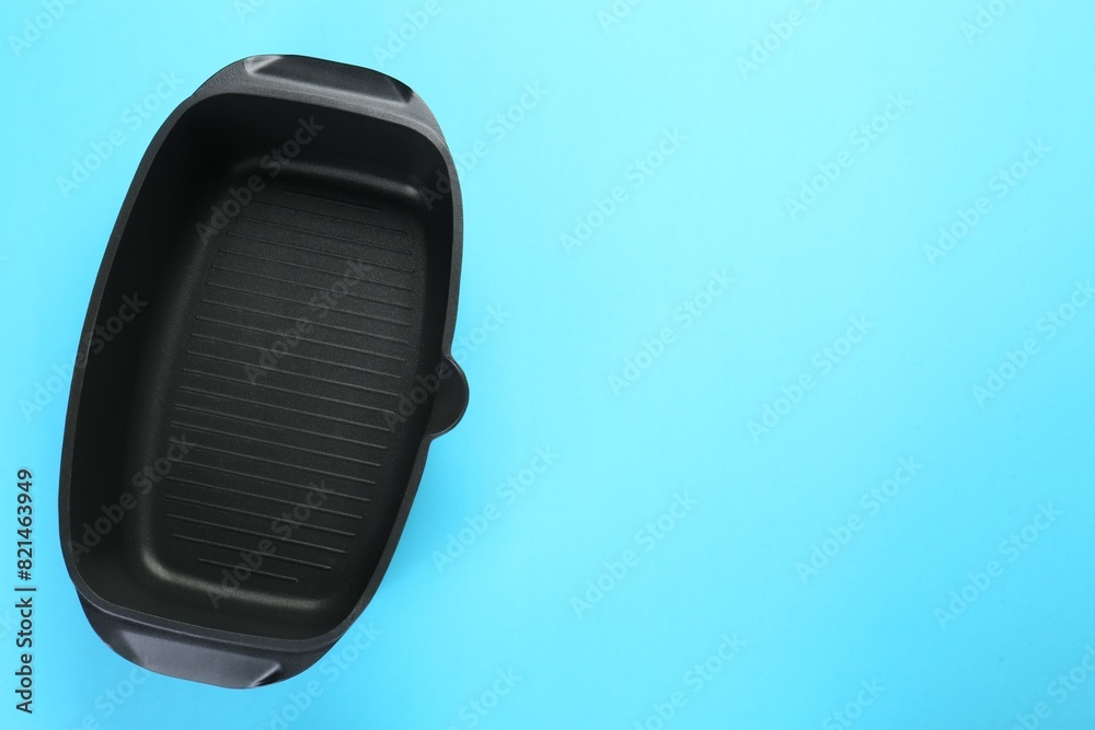 Black pot on light blue background, top view. Space for text Black pot on light blue background, top view. Space for text