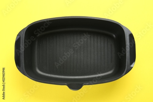Black pot on yellow background, top view
