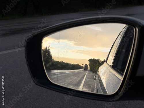 Sunset sky reflect in rearview mirror of car.