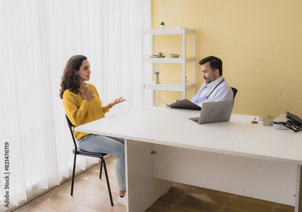 Portrait latin woman sick mentally sit chair with man doctor caucasian sitting two people talk check health and treat patients talk helping support explain medicine sick person inside hospital room Portrait latin woman sick mentally sit chair with man doctor caucasian sitting two people talk check health and treat patients talk helping support explain medicine sick person inside hospital room