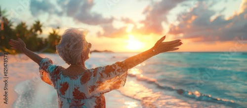 Elderly Woman Experience Serene Joy Amidst Sunset Hues on Tropical Beach photo