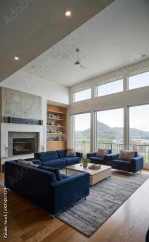 Modern professional photograph of a navy blue and silver luxury living room interior with floor-to-ceiling windows and a cozy fireplace