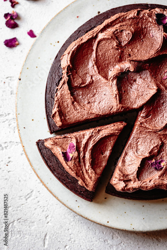 Chocolate cake with chocolate frosting and dried rose petals photo