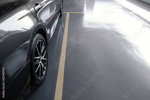 modern car in parking lot, anti slip coating floor for safety, car parked in the right position in modern building carpark area, image with copy space for banner background, diagonal composition photo
