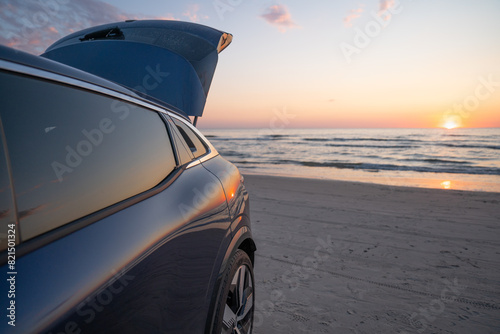 Hatchback trunk open against a background of sunset over sea