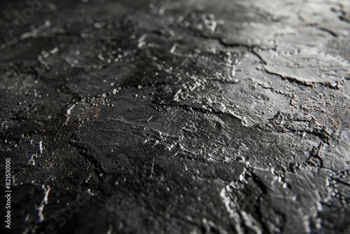 The image is of a black and grey surface with a rough texture © Irfanan