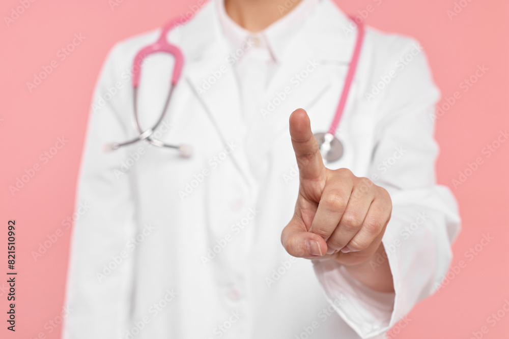 Doctor with stethoscope pointing on pink background, closeup Doctor with stethoscope pointing on pink background, closeup