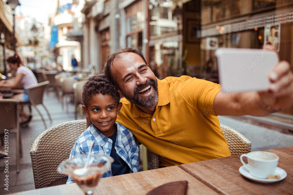 Father and son taking selfie at outdoor cafe Father and son taking selfie at outdoor cafe