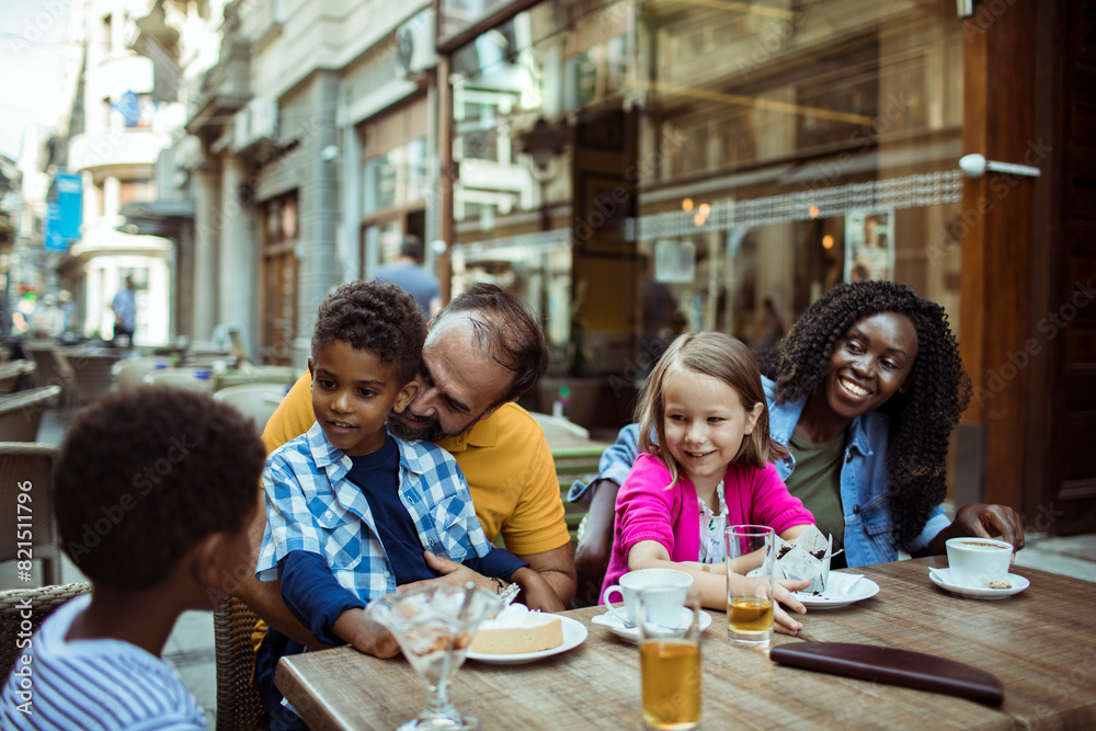 Happy multiethnic family enjoying time at a cafe together Happy multiethnic family enjoying time at a cafe together