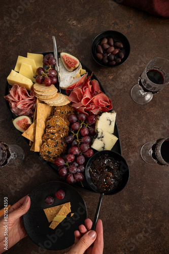 Female Hands Digging into Premium Cheese Platter photo