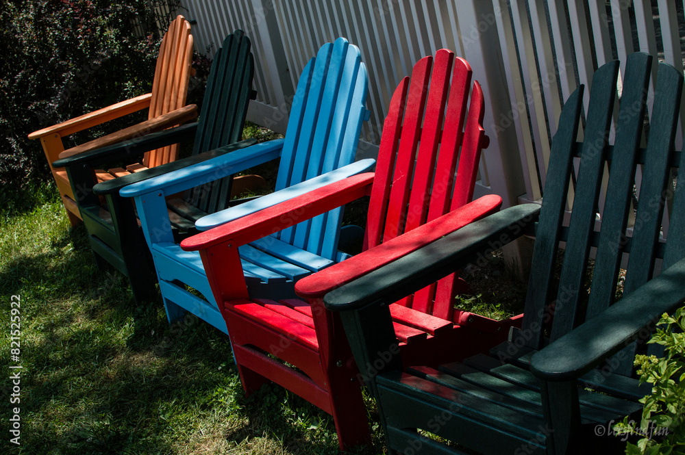 Colorful Lawn Chairs in a Row by Picket Fence Colorful Lawn Chairs in a Row by Picket Fence