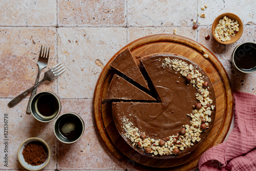 Landscape shot of chocolate cheesecake with hazelnuts and coffee on tiles photo