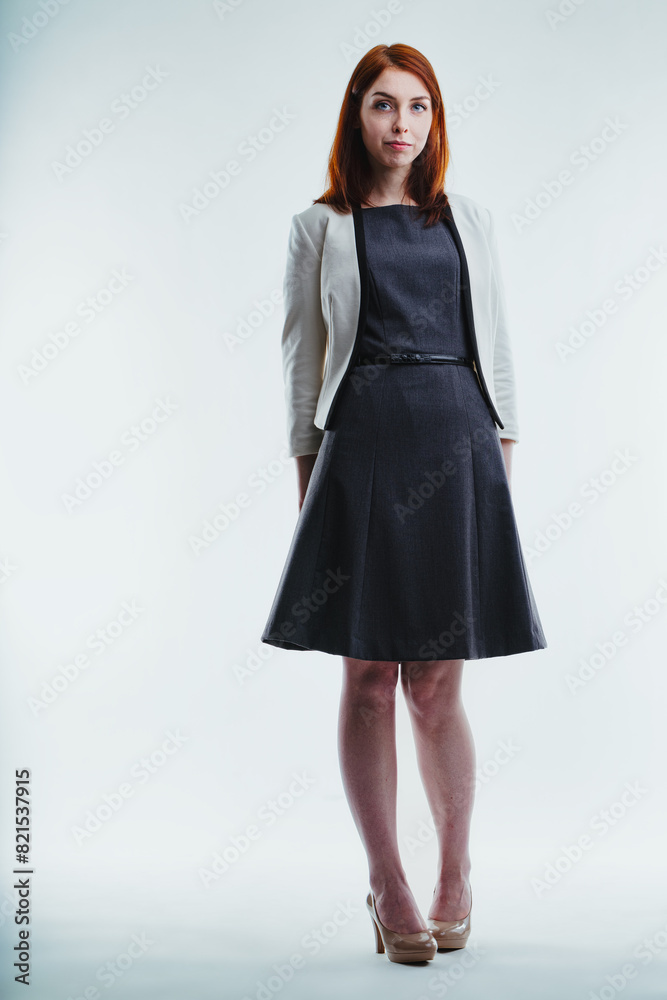 Elegantly dressed redhead stands, looks assuredly Elegantly dressed redhead stands, looks assuredly