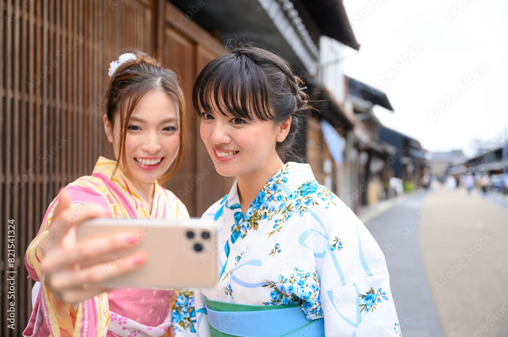 古民家を散歩して写真を撮る浴衣女性2人
