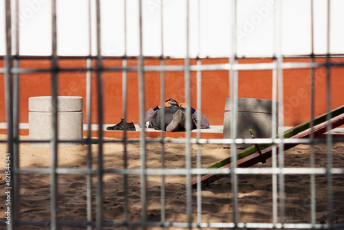 Workerman relaxing lying down the sunlight on a playing park in his break time