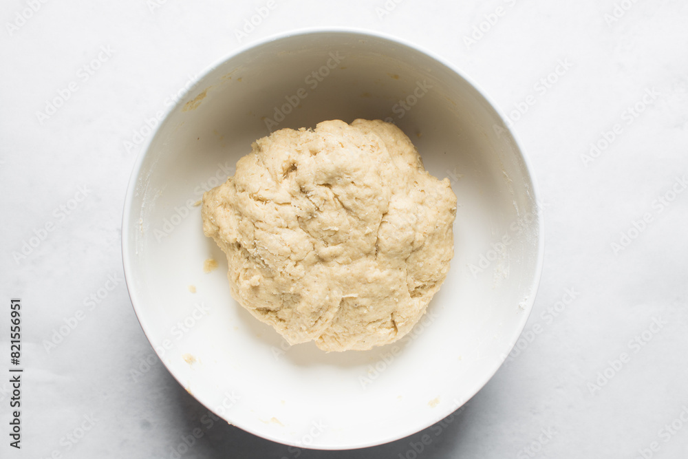 overhead view of dough for making nigerian egg roll in a white ceramic bowl, process of making nigerian egg roll and small chops overhead view of dough for making nigerian egg roll in a white ceramic bowl, process of making nigerian egg roll and small chops