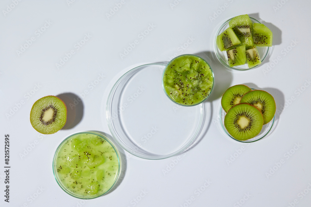 Obraz premium A glass tray in round shaped, decorated by a small dish of chopped kiwi in the corner, still has blank space for showing product has kiwi origin over white background. Displaying space, top view