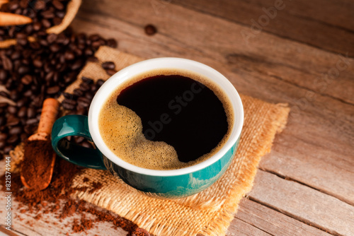 Black coffee with green cup and roasted coffee beans brown sugar and a cup of hot espresso coffee flat top view on a dark background