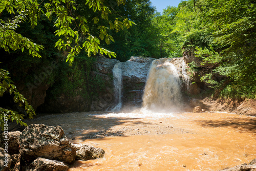 View of the waterfall Noise of the waterfall cascade of the Rufabgo creek on a sunny summer day, Kamennomostsky, Republic of Adygea, Russia photo
