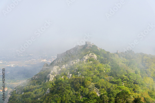 aerial view from the Pena Palace of the Arab castle in the mysterious fog, foggy landscape. Sintra, Portugal. Castelo dos Mouros photo