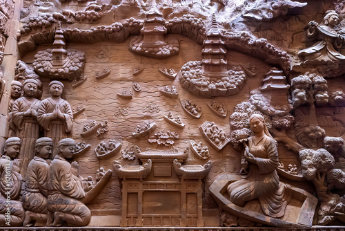 Stone carved base-relief of Ky Lan temple in Ninh Binh, Vietnam. Human figures and floral ornament bas-relief. Traditional Champa architectural details. Ancient building with stone carving decor photo