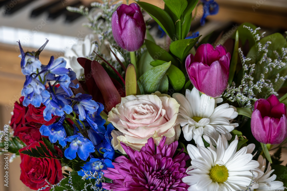 Obraz premium Close up texture background of an indoor florist’s bouquet arrangement containing colorful flowers, with defocused background