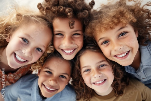 A group of children with curly hair are smiling and posing for a picture. The children are all different colors, but they all have the same happy expression on their faces