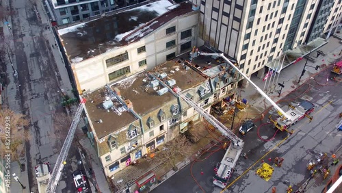 Aerial of Canadian firefighter handling apartment building fire accident in the downtown area in Ville-Marie, Montreal, Quebec, Canada photo