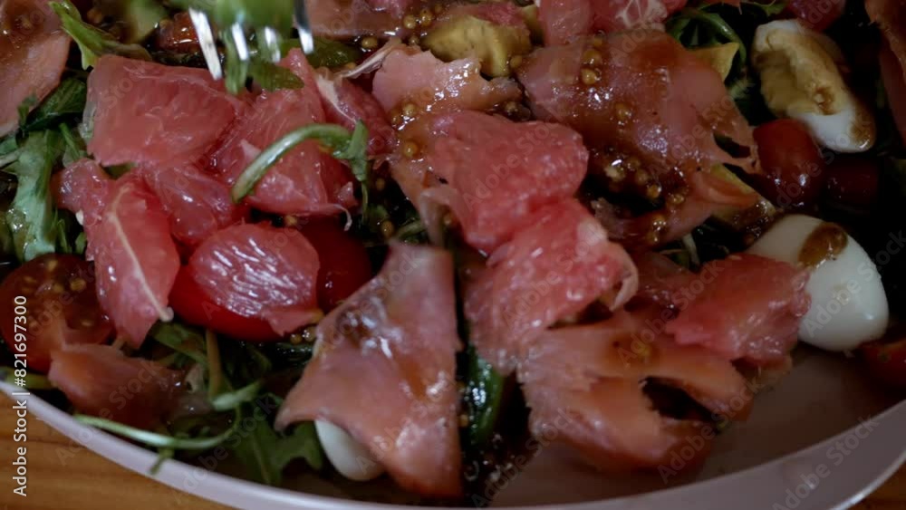 Salad - salmon, arugula, grapefruit, cherry tomatoes, quail eggs, avocado. Closeup