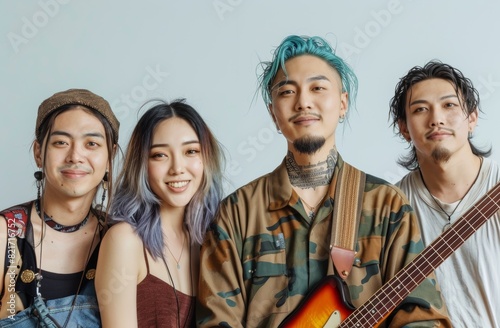 Group portrait of an asian band of four people, singer, guitarist, bassist, and drummer with green dyed hair isolated on white background. Japan rock band.