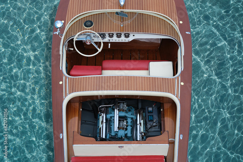 Luxury speedboat made of varnished wood with an open engine on clear turquoise water, top view. Top view of a wooden expensive exclusive boat. photo