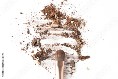 Crushed brown eyeshadow smear with cosmetic make up brush on white isolated background