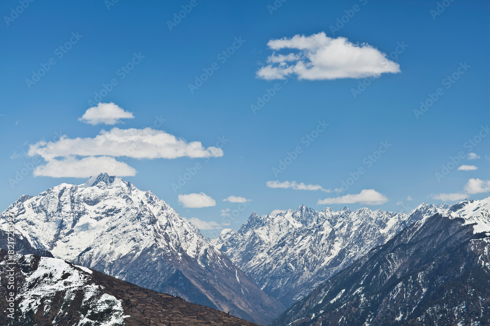 Snow Capped Himalayan Mountains With Blue Skies and puffy clouds Snow Capped Himalayan Mountains With Blue Skies and puffy clouds