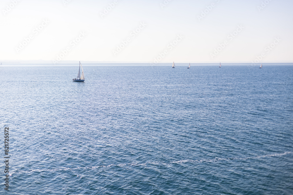 Sailboats on Lake Garda, Italy, under a clear sky