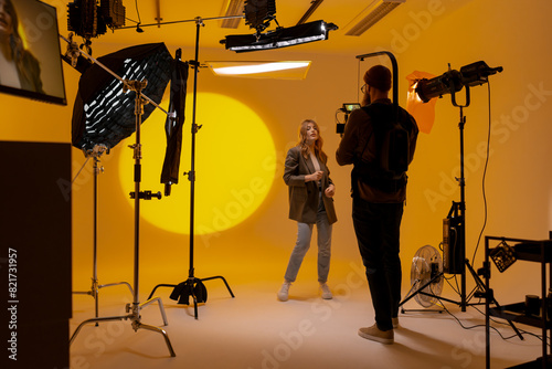 Videographer capturing footage in a yellow room with a camera