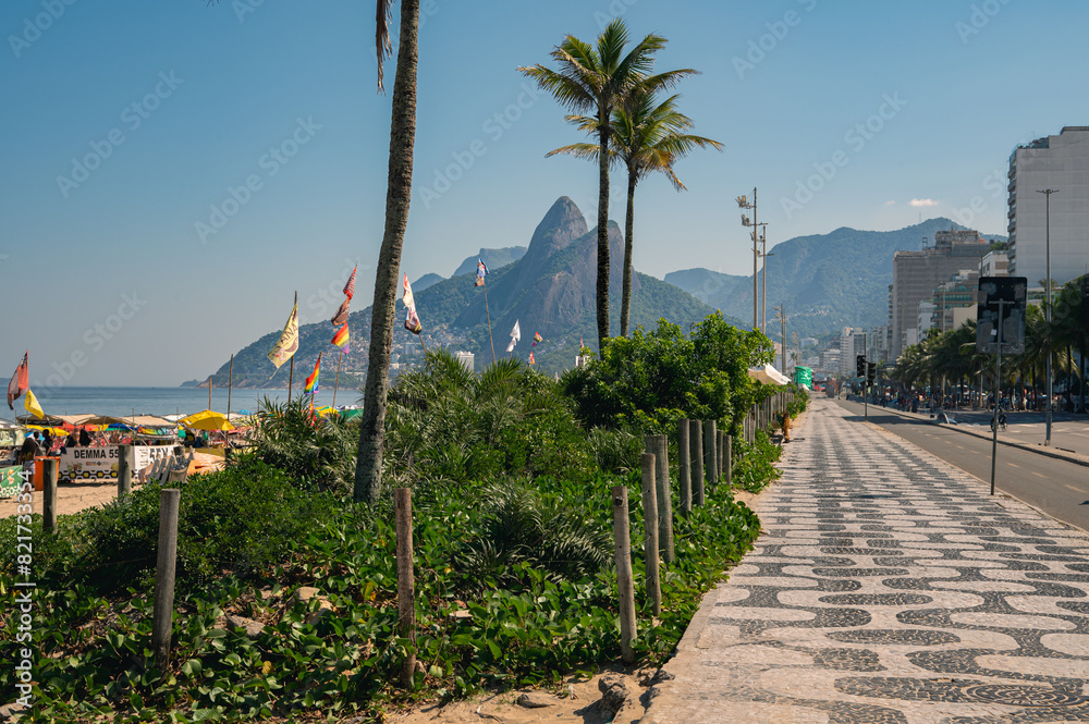 Obraz premium View of Leme beach and Copacabana beach with palms and mosaic of sidewalk in Rio de Janeiro, Brazil. Copacabana beach is the most famous beach in Rio de Janeiro. Sunny cityscape of Rio de Janeiro