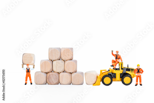 Miniature worker with wooden cube stack and yellow truck isolate on white background, business goal, building block to success