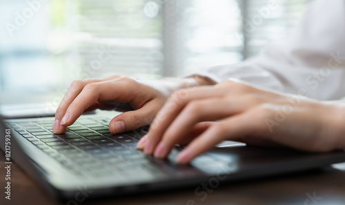 Hands typing keyboard on laptop with working online.