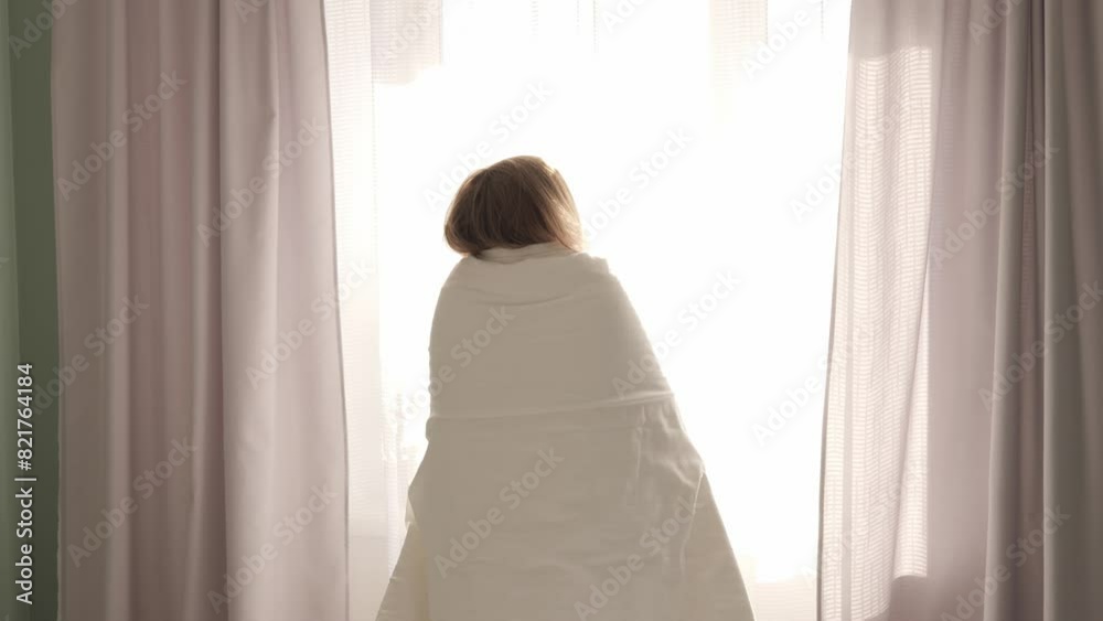 Woman wrapped in blanket enjoys morning sun. She smiles warmly, basking in sunlight, embracing a new day. Perfect footage for themes of joy, relaxation, and positivity with sun shining brightly. Woman wrapped in blanket enjoys morning sun. She smiles warmly, basking in sunlight, embracing a new day. Perfect footage for themes of joy, relaxation, and positivity with sun shining brightly.