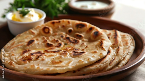 Close-up of golden-brown aloo paratha, oozing with savory potato filling, served with creamy butter.