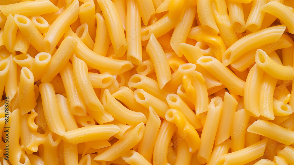 A close up of yellow pasta with a yellow sauce. The pasta is cooked and has a creamy texture. Creamy Mac and cheese close up full frame background banner
