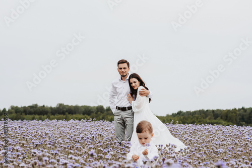 mom, dad and son on the background of a blooming purple field