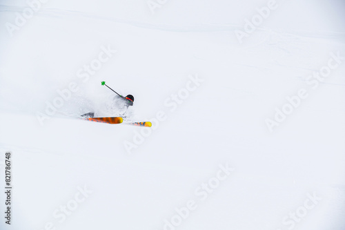 skier on the piste, going down the slope among the Alpine mountains, which are not visible due to cloudiness