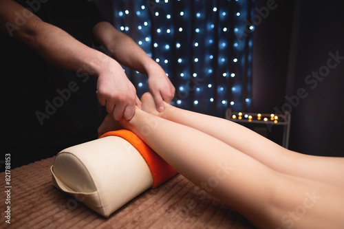 woman is given a relaxing massage with essential oils, a man massage therapist kneads her thighs with his hands, anti-cellulite procedures
