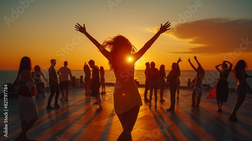 Joyful people dancing at sunset by the sea, celebrating life and happiness in a stunning natural setting with arms raised in joy.